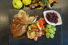 Half a roast Pheasant presented on a slate with side veg
