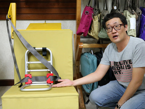 Engineer I.S. Choi reviews the original Pico travel car seat frame and safety belt position