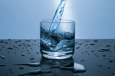 the image shows a cold glass of water being poured
