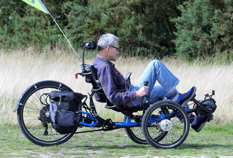 the image shows a man riding a trike in a field