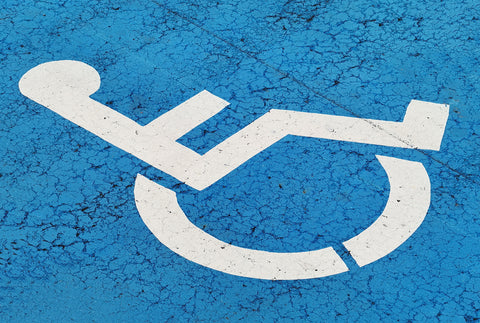 A photo of a disabled sign – a wheelchair – with a mottled blue backgroundA photo of a disabled sign – a wheelchair – with a mottled blue background
