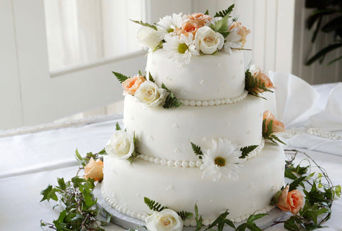 the image shows an expensive looking wedding cake on at table