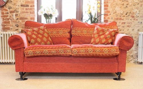 An orange sofa in a cosy looking lounge