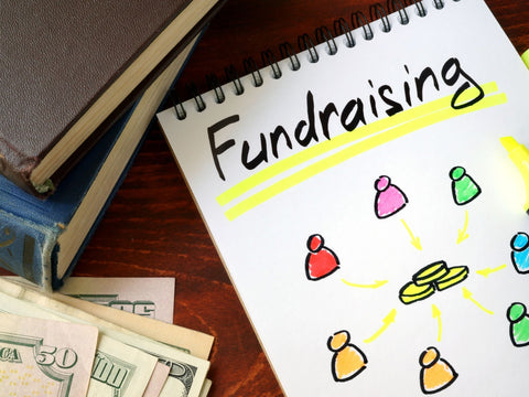 The image shows fundraising ideas on a notepad