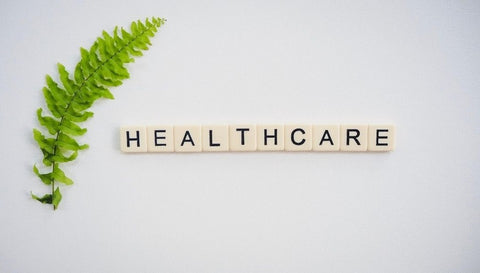 the image shows the word healthcare spelt out in white tiles on a wall
