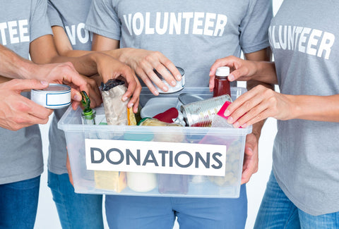 the image shows a group of volunteers with a donations charity box