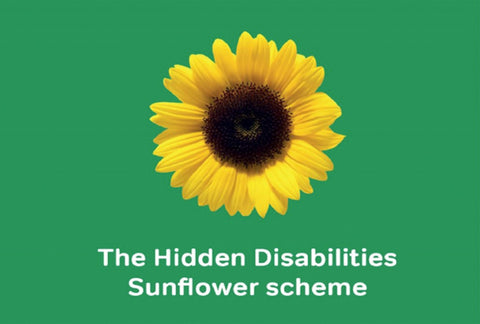 A sunflower against a racing green background colour with the words – The Hidden Disabilities Sunflower Scheme – underneath