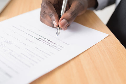 the image shows a man signing a contract