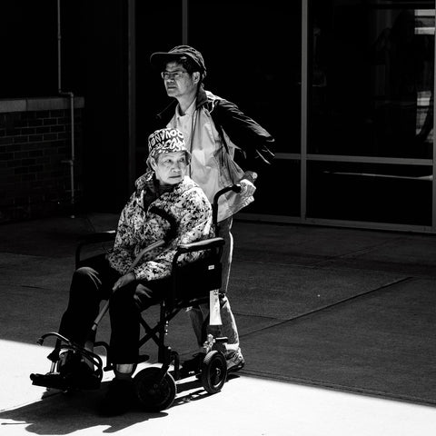 the image shows a person being pushed in a wheelchair