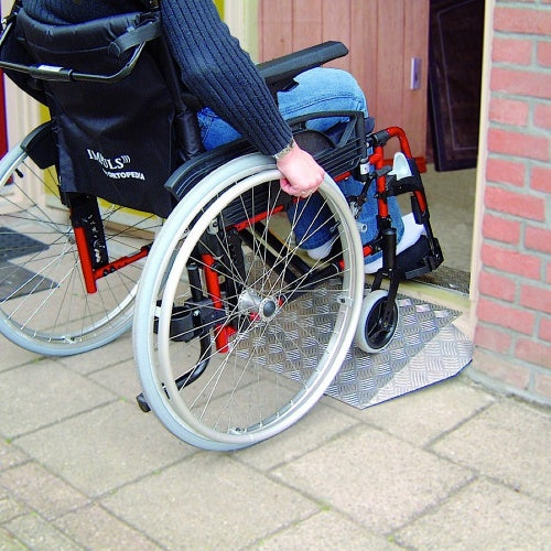 A man in a wheelchair going up a ramp