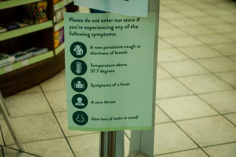 the images shows a covid-19 warning sign at the entrance to a supermarket