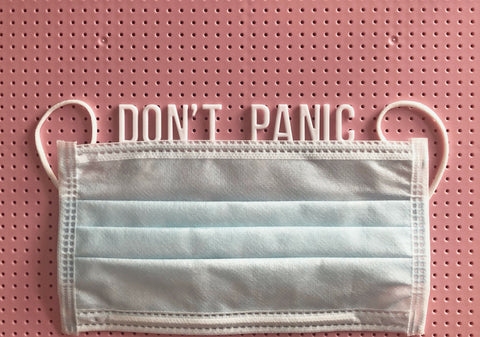 the image shows a face mask with the words don't panic written above it