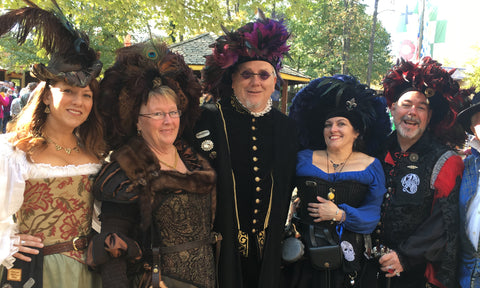 A couple of men wearing Tudor style feathered Hats amongst the beauties at the Maryland Renaissance Festival