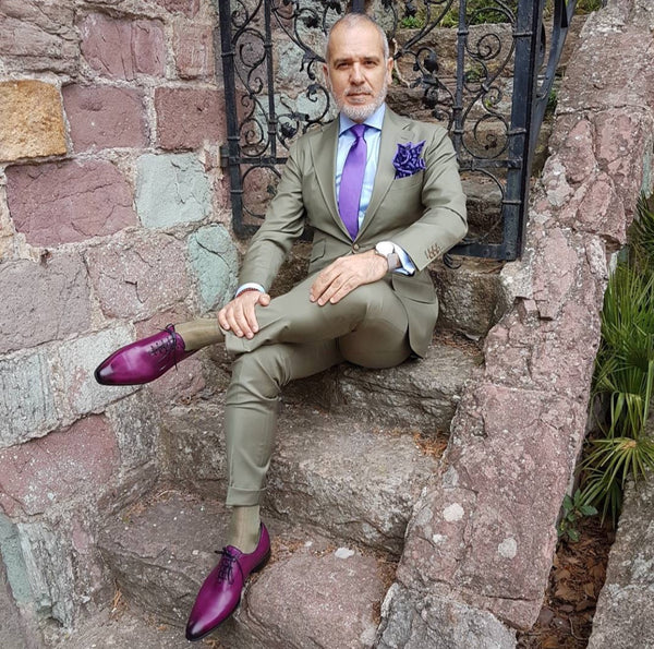 Suited Traveller wearing Thomas Bird plum wholecuts with a pale green suit