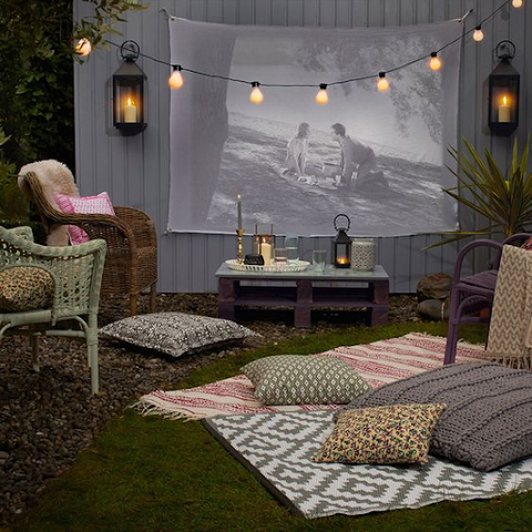 Outdoor date night with blankets, pillows and a screen projector