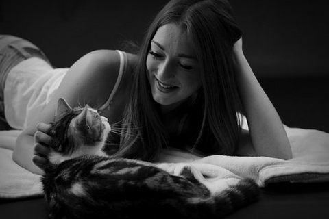 girl with her cat on a bed 