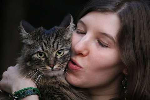 lady cuddling her tabby cat 