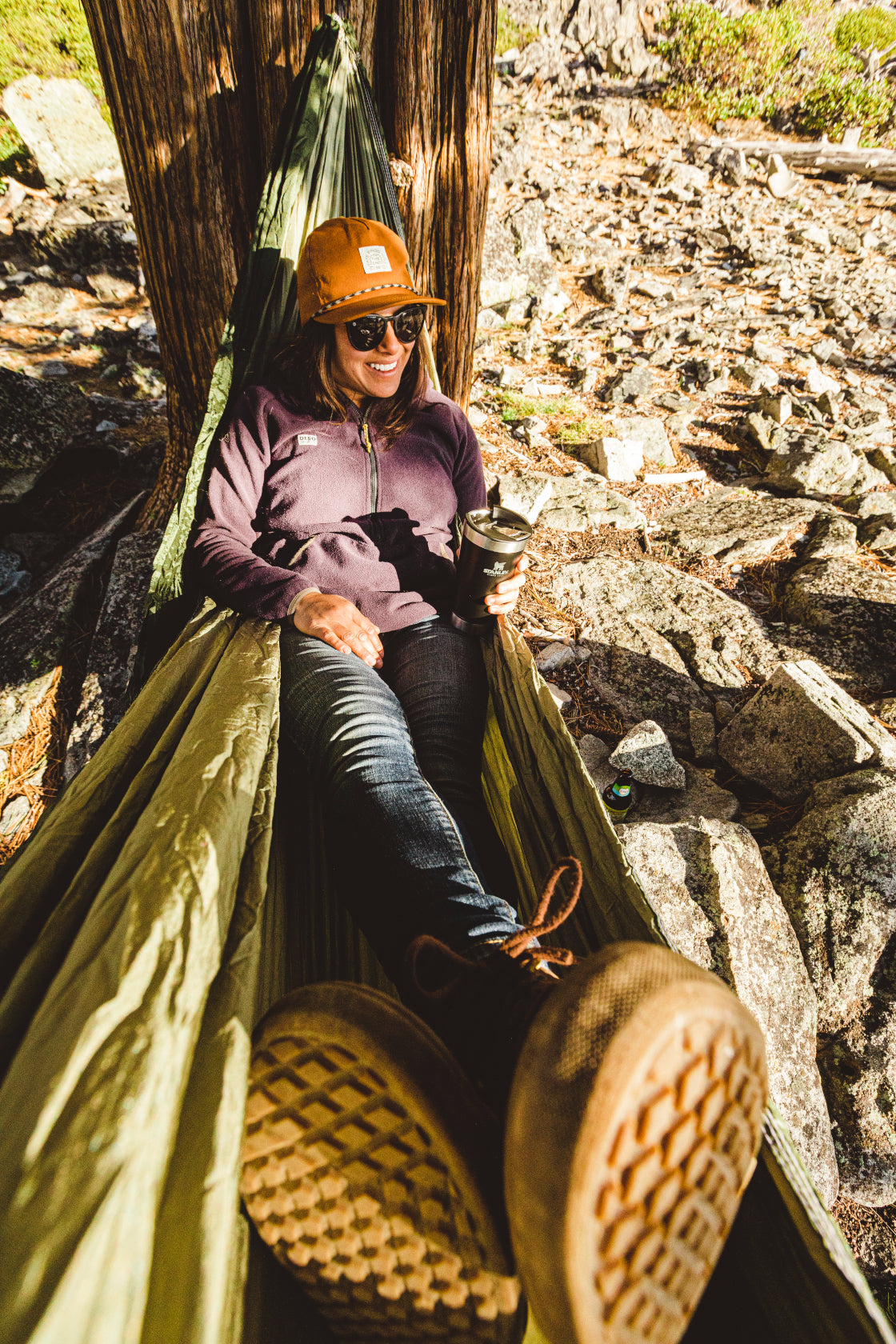 girl relaxing in a hammock tied between trees