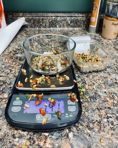 The Truweigh Wave Digital Washdown scale is on a granite counter weighing a bowl of a rice dish. The food is spilled all over the scale and counter.