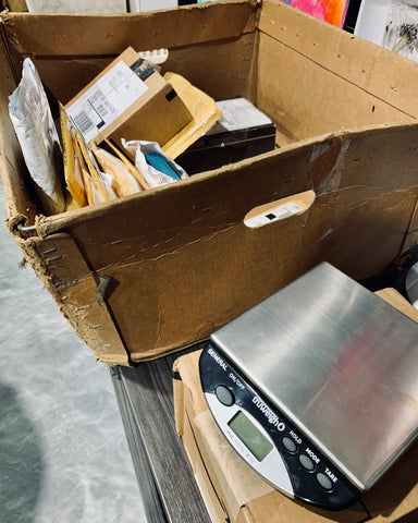 The Truweigh General bench scale sits next to a large bin filled with mail and packages.