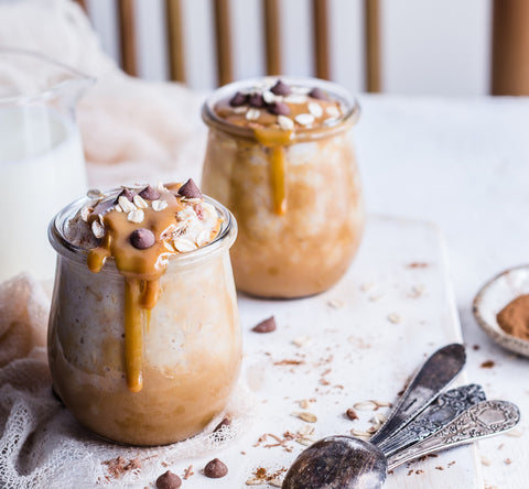 glass pots of oat meal with drizzled caramel chocolate chips. 