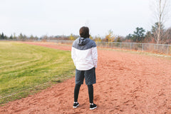 Stressed athlete standing on track with back to camera