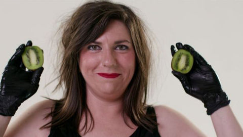 Maeve Marsden holding up kiwi fruits with latex gloves - still taken from Lady Sings It Better and Claude Educational Video | Nikki Darling Australia