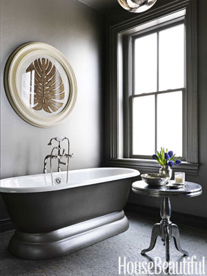 dramatic dark gray bathroom with artwork, freestanding bathtub, & small table with purple flowers... Bathroom Design Trends: Gorgeous Gray Inspiration