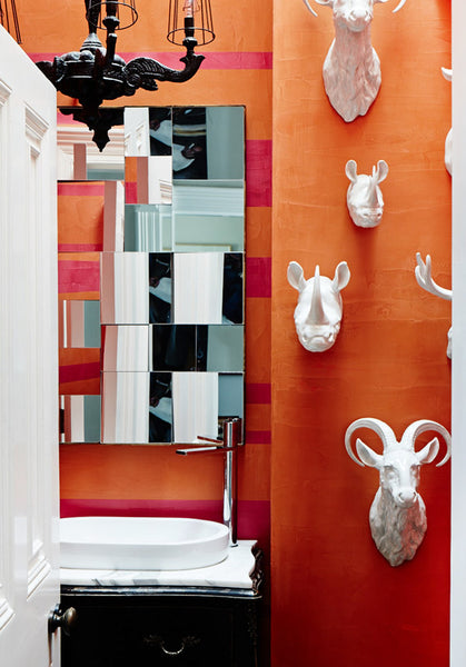 fun contemporary orange bathroom with mirror and white ceramic animal head statues... Beautiful Bathroom Inspiration: Orange Bathrooms from The Bathroom Bliss Blog by Rotator Rod, the original curved shower rod that rotates!