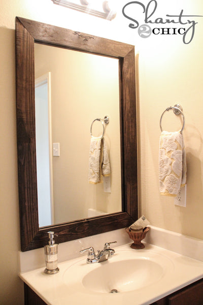 DIY dark wooden bathroom mirror frame in small bathroom... Easy Bathroom Updates for a More Luxurious Rental Apartment