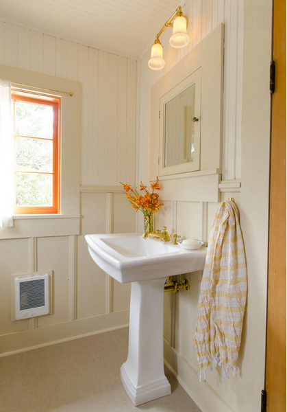 cream colored bathroom with wainscoting, pedestal sink, and orange accents and flowers... Hottest Space-Saving Bathroom Trends for 2015 from The Bathroom Bliss Blog