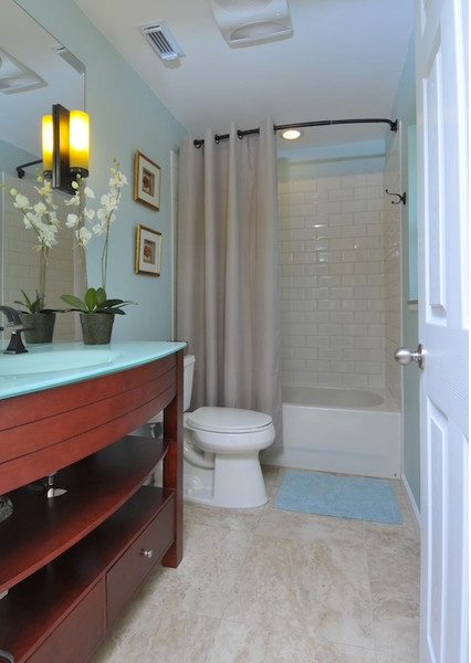 beautiful light blue bathroom with cherry wood cabinets, white orchid, light shower curtain, dark shower rod... Should You Change Your Shower Rod for Winter? from Bathroom Bliss by Rotator Rod