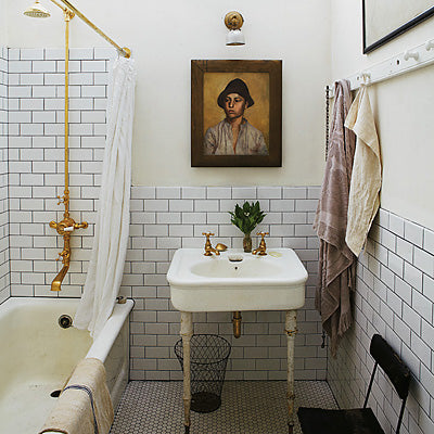 small white bathroom with subway tile, white shower curtain, a male portrait painting, and brass accents... Small Bathroom Chic: Artwork Brightens Bathroom Space from Bathroom Bliss by Rotator Rod