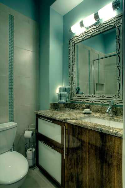 beautifulsmall bathroom with blue accents, wood cabinets, granite countertop, framed mirror... Tiny Bathroom, Big Ideas: 5 Space Saving Ideas for Small Bathrooms by Tradewinds Imports from The Bathroom Bliss Blog by Rotator Rod