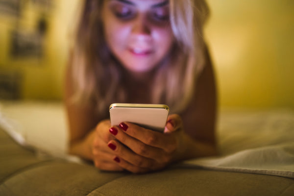 woman with phone in bed