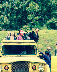 Group of people riding a truck through Macadamia farm