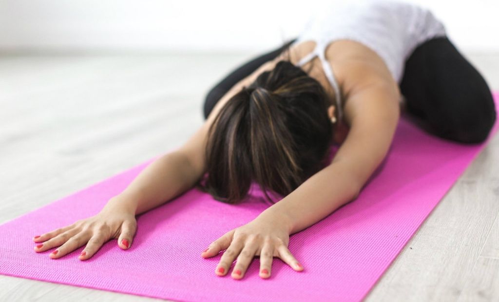 Woman practising the Yoga move known as 'Child's Pose' 