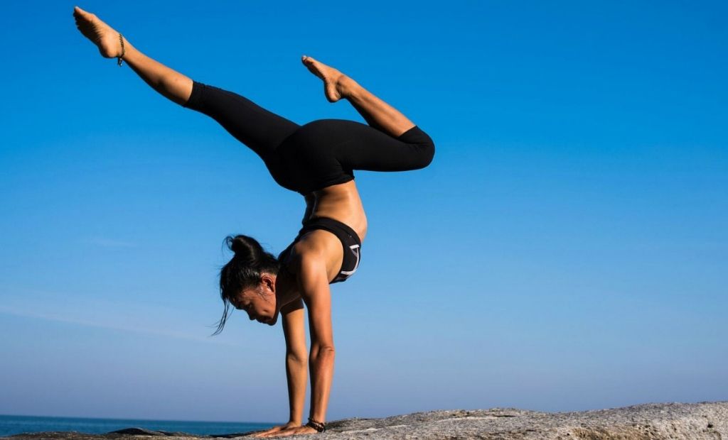 Woman practising yoga atop of a mountain