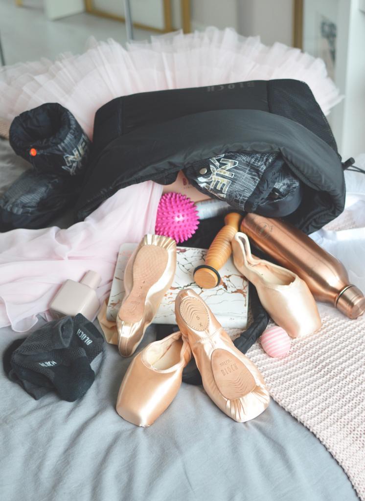 A BLOCH dance bag filled with BLOCH essentials Pointe Shoes, Warm Up Booties, tutu, Foot Roller and water bottle