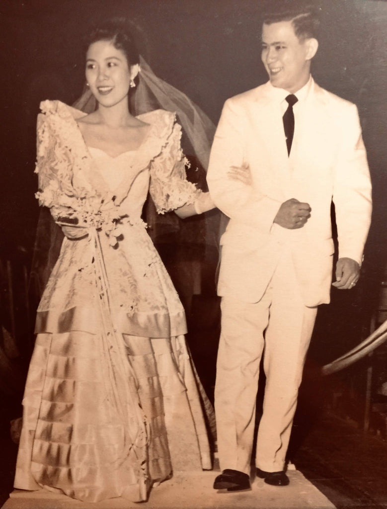Bride in a traditional Filipiniana terno wedding gown with a groom dressed in a white suit in the Philippines.