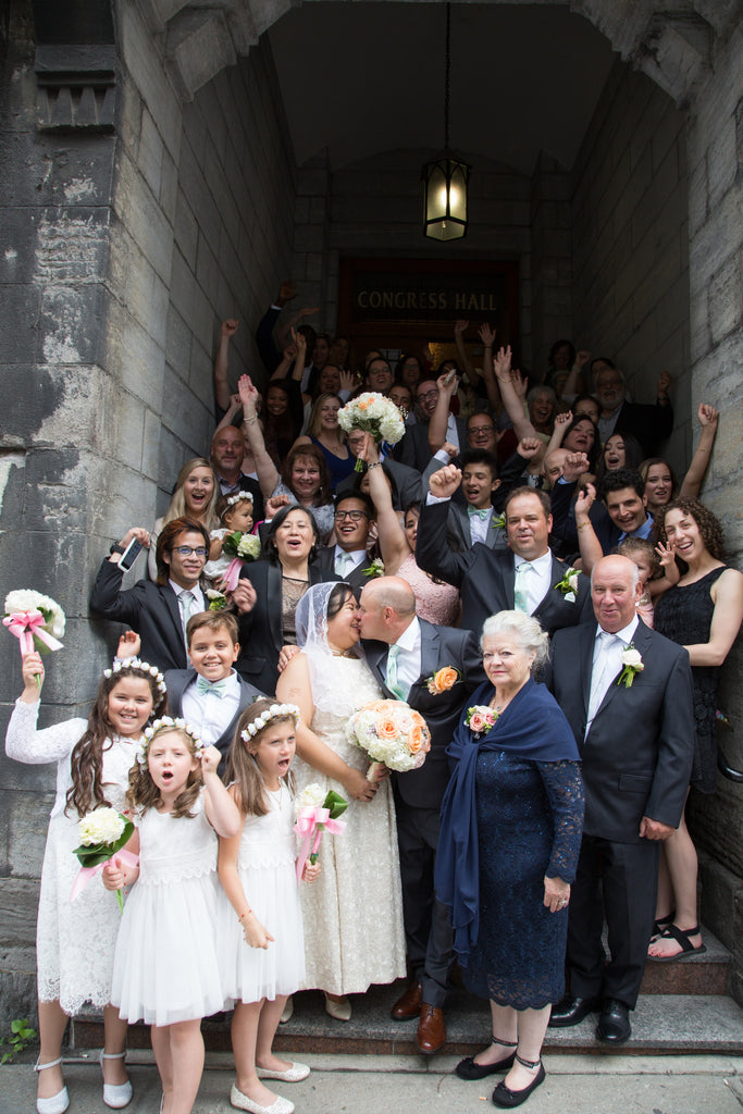 A Filipino and Italian couple are surrounded by their friends and family at the church outside of their small and intimate wedding in Montreal.
