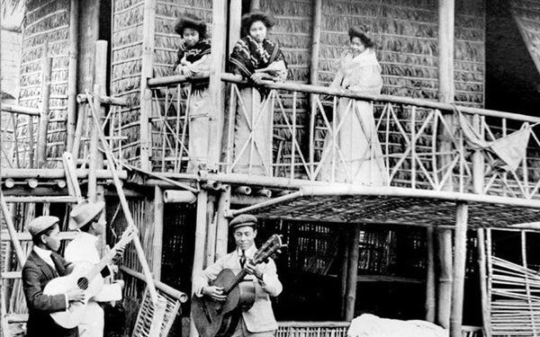 A young man together with friends practicing the harana, or the serenading of a maiden below her balcony.