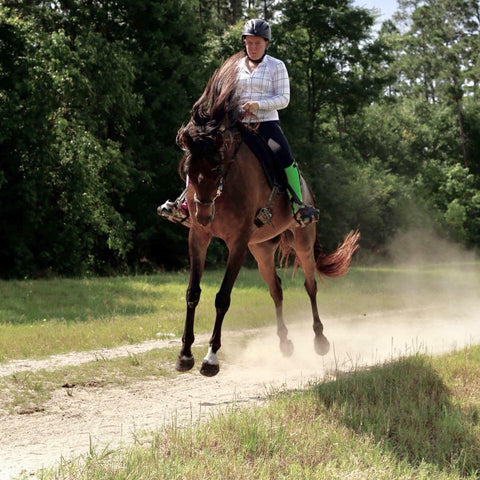 Devan Horn on bucking horse wearing pink and green half chaps from Just Chaps.