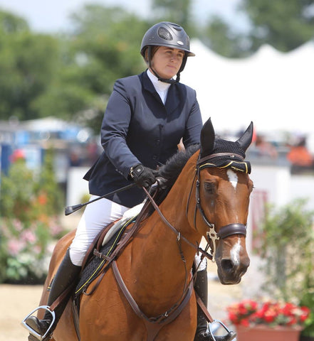 Victoria Colvin wearing her grand prix show coat while show jumping.