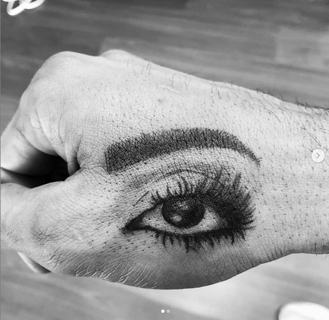 Eye Top of Thumb and Hand Tattoo