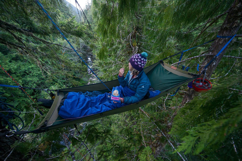 Kelli Martinelli eating freeze-dried cheesecake bits while in hammock up high in trees