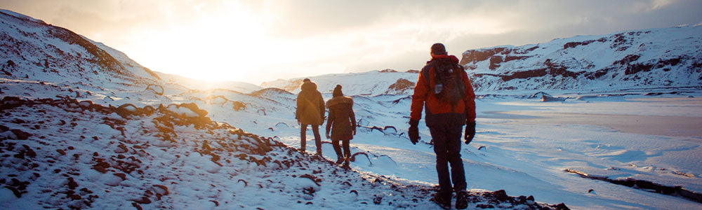 three backpackers hiking in snow