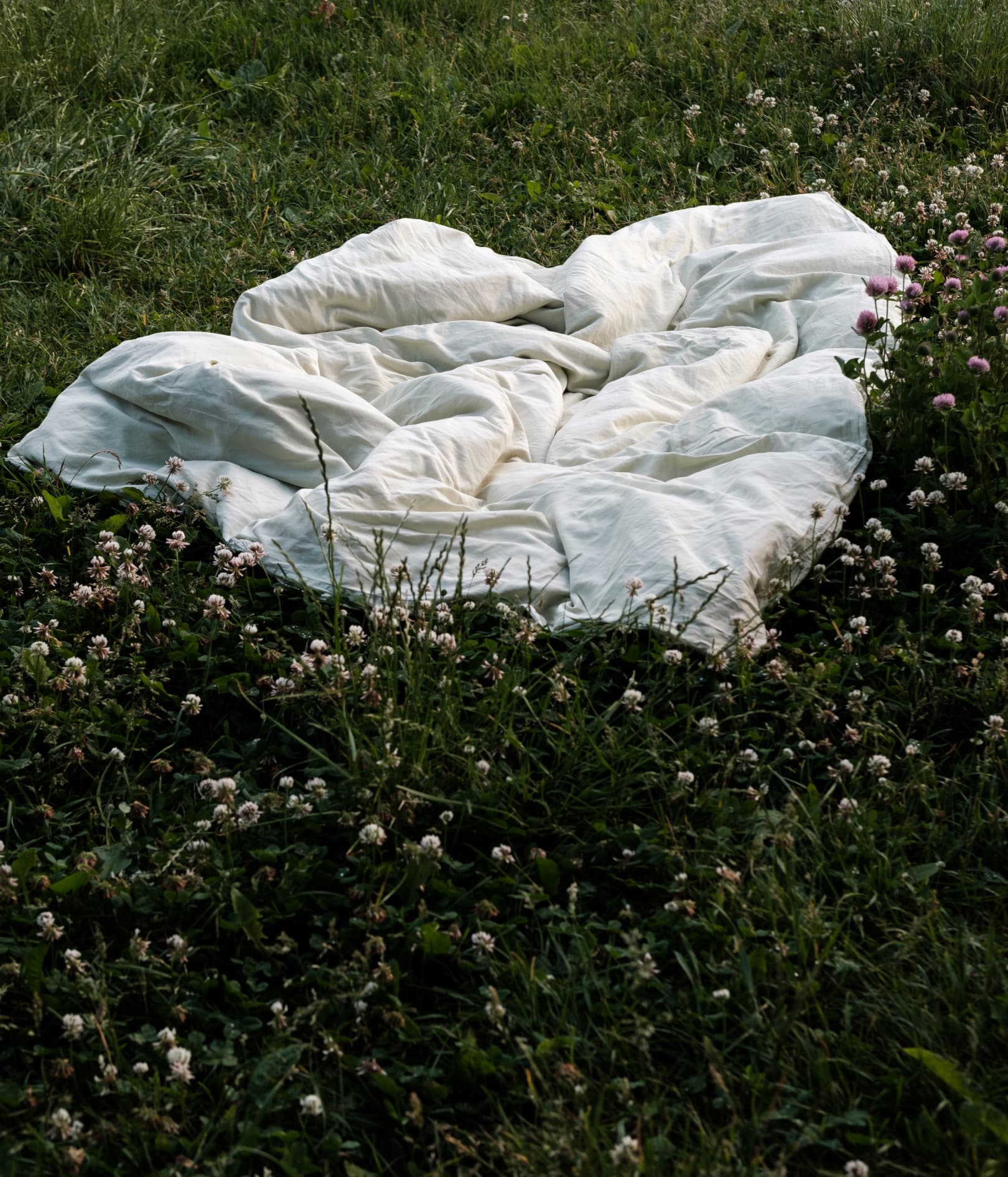 Dyne med mintgrønt sengetøy fra MYYK i blomstereng.