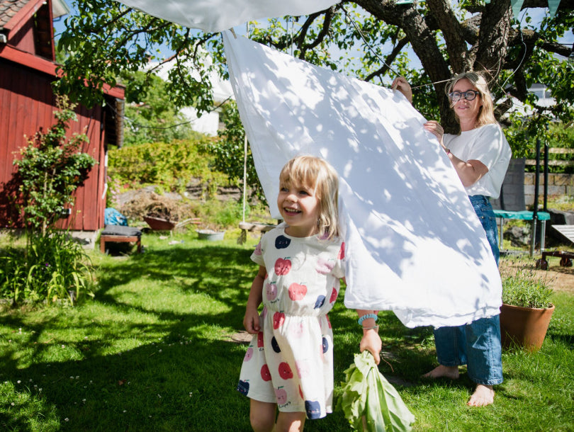 Mor får hjelp til å henge opp sengetøy