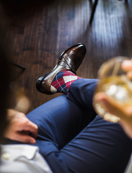 man wearing red and blue argyle socks